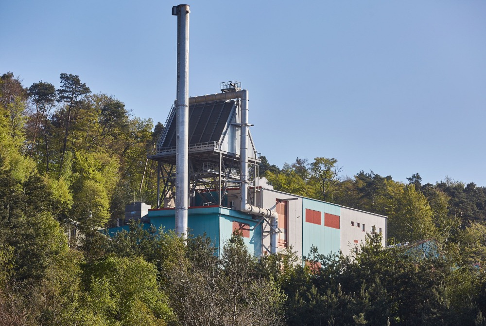 Biomasseheizkraftwerk der ZAK zwischen Waldhügeln zur nachhaltigen Energiegewinnung aus Bioabfällen