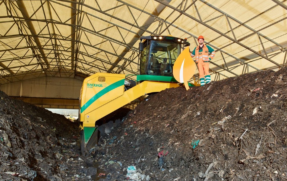ZAK Bioabfallbehandlung mit Radlader beim Umsetzen kompostierter organischer Materialien in überdachter Rottehalle