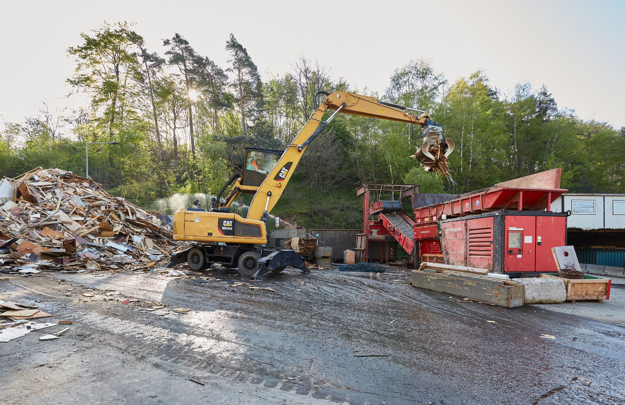 Mechanische Altholzaufbereitung bei der ZAK mit Bagger und Zerkleinerungsanlage für Biomasse-Produktion