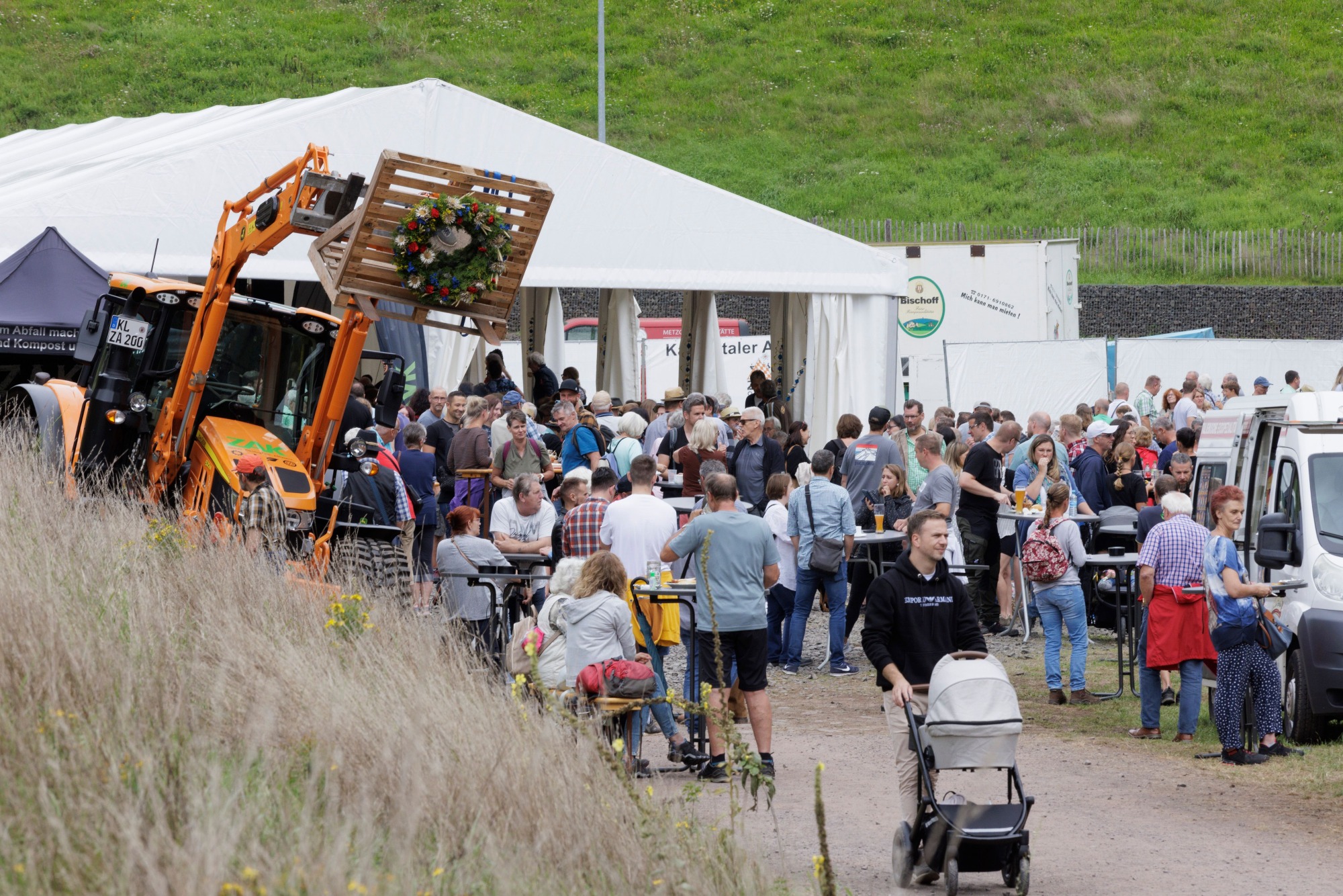 ZAK Almabtrieb mit vielen Besuchern vor Festzelt und geschmücktem Radlader