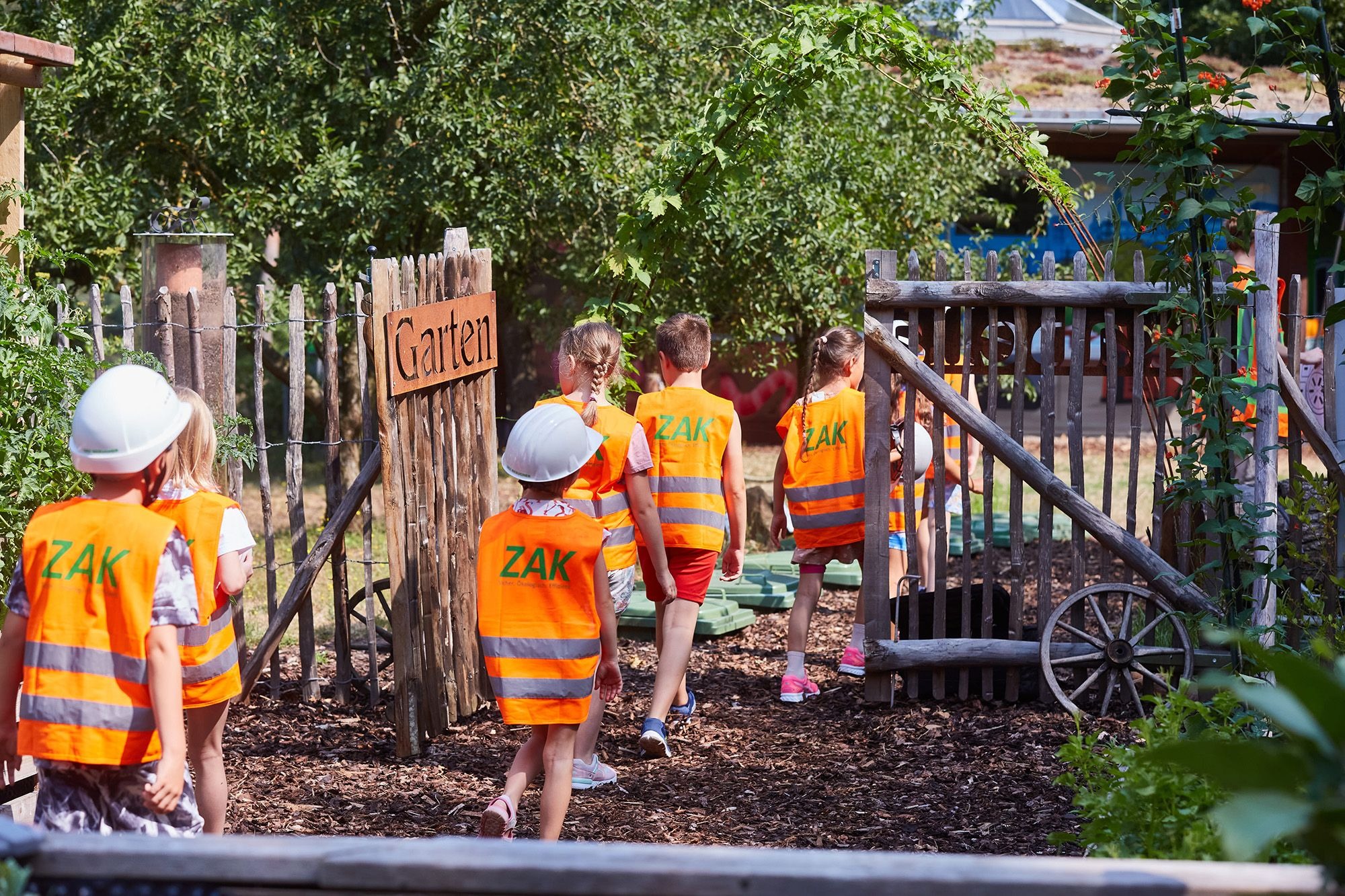 Kinder beim Erkunden des Umwelterlebniszentrums mit Kompostplatz und Holzspielgeräten