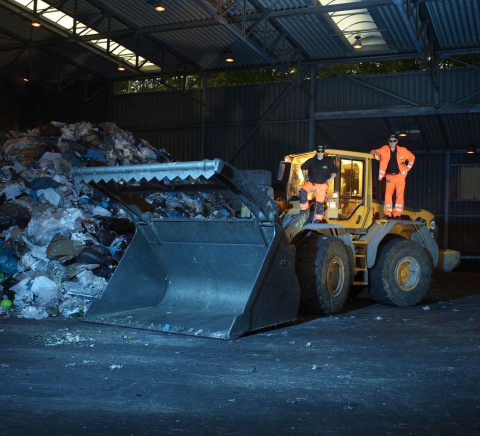 Radlader bewegt Abfallmaterial in der ZAK Umladestation zur Vorbereitung für Transport oder Weiterverarbeitung unter Hallendach