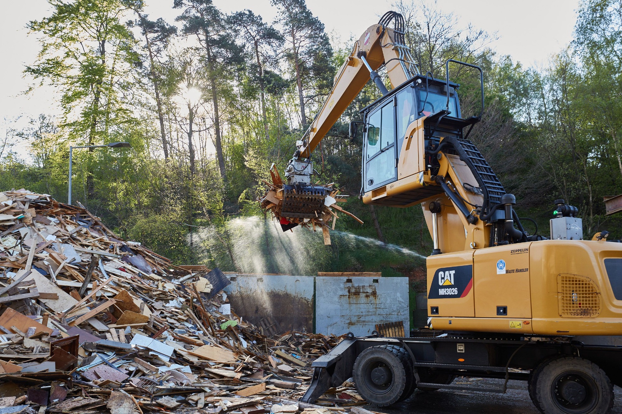 CAT-Mobilbagger mit Greifer sortiert Altholz bei der ZAK für die nachgelagerte Aufbereitung zu Biomasse