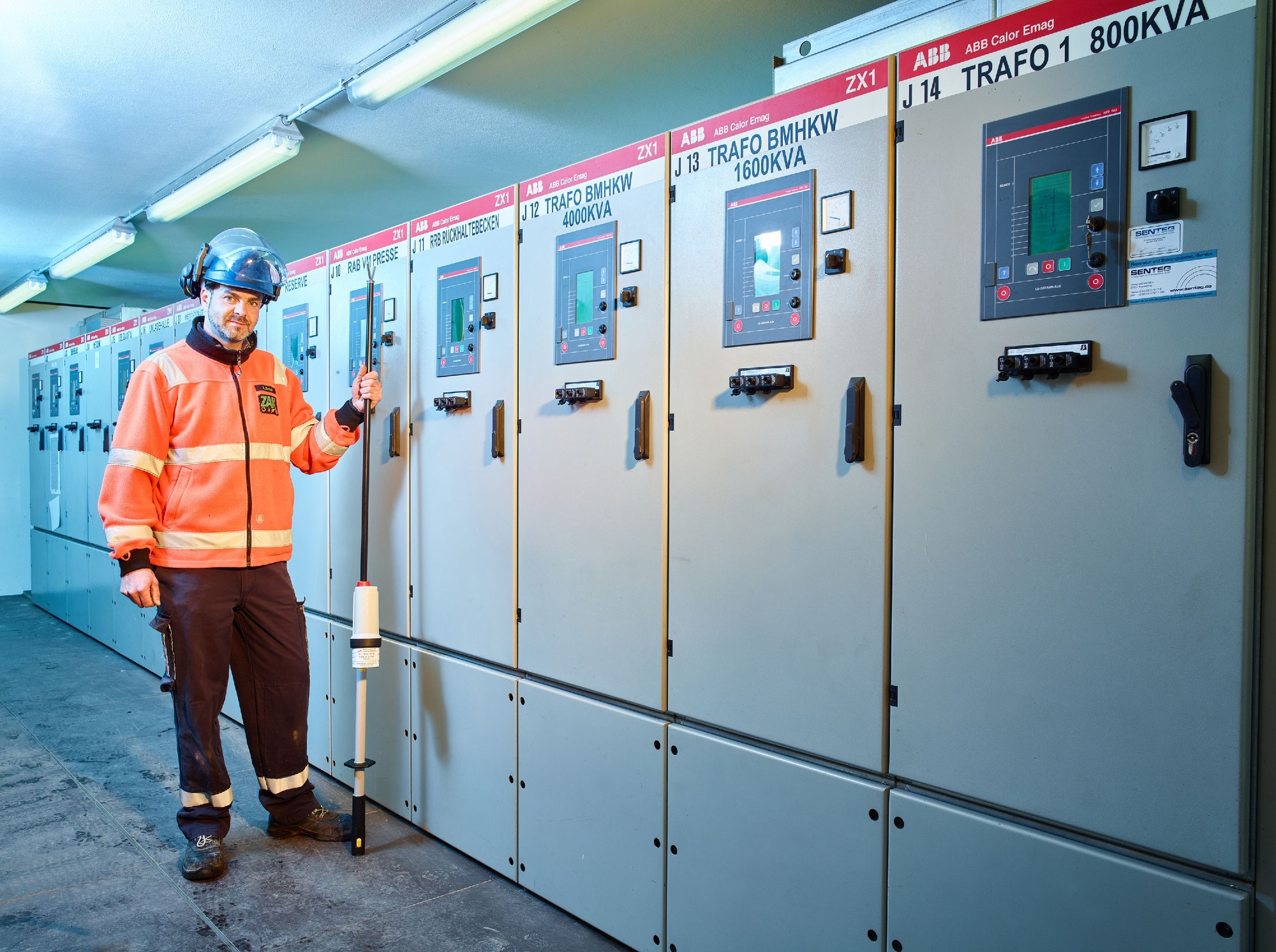 ZAK Mitarbeiter in Schutzkleidung vor Stromversorgungs-Schaltanlage