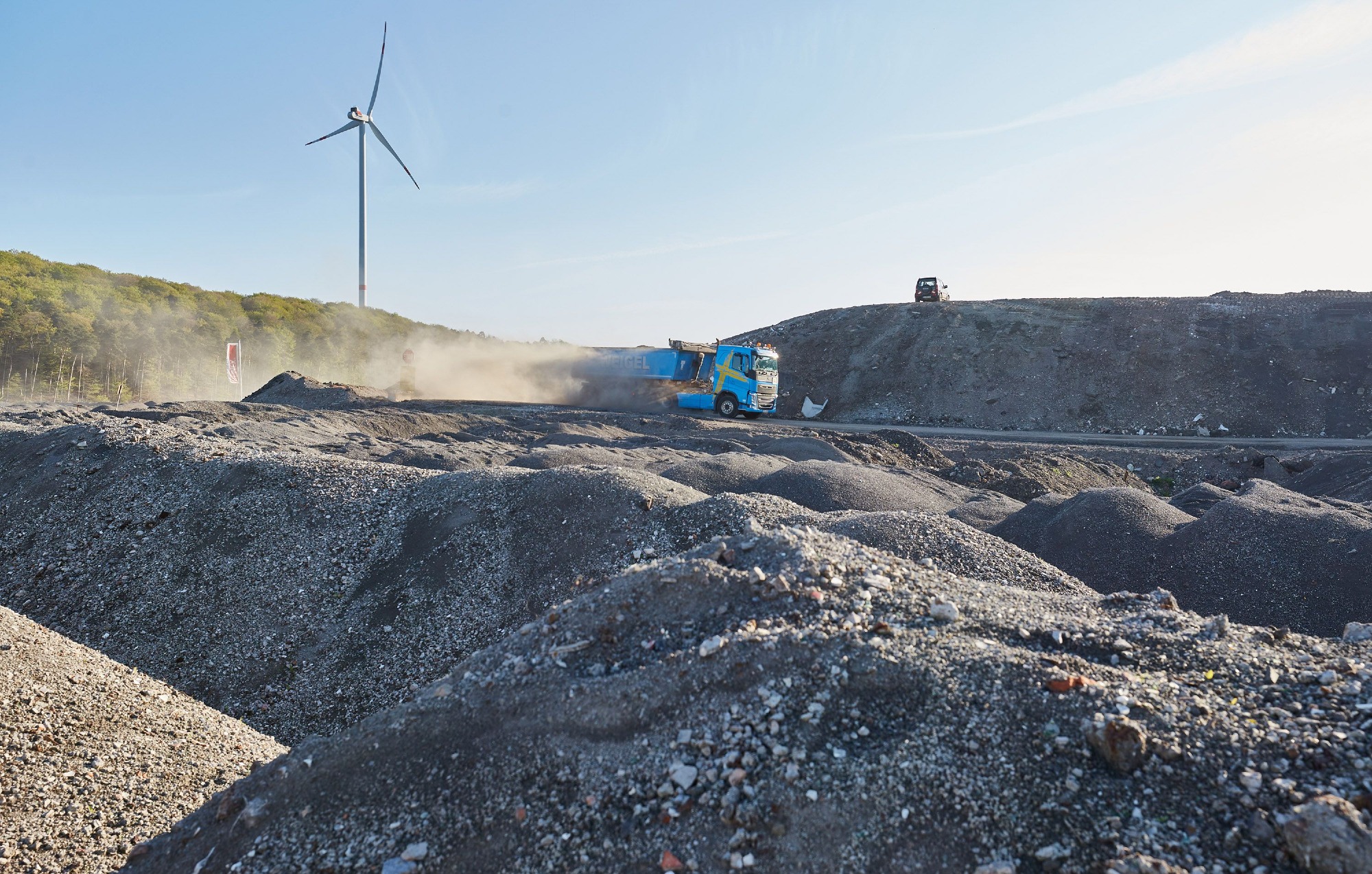 ZAK Deponie Kapiteltal mit Windkraftanlage und Verdichtungsfahrzeug bei der fachgerechten Abfallablagerung
