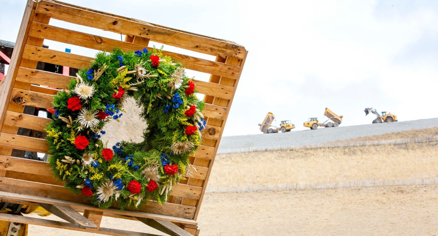 Festlicher Kuhkranz mit roten und blauen Blumen am Holzzaun beim ZAK Kapiteltaler Almabtrieb als traditionelles Symbol für die erfolgreiche Rückkehr der Tiere von der Almweide