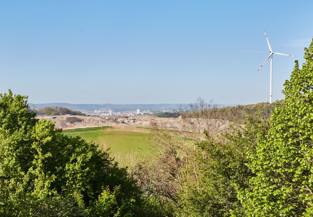 Blick vom ZAK Deponie-Gelände auf Kaiserslautern mit Windkraftanlage zeigt landschaftliche Integration des Standorts