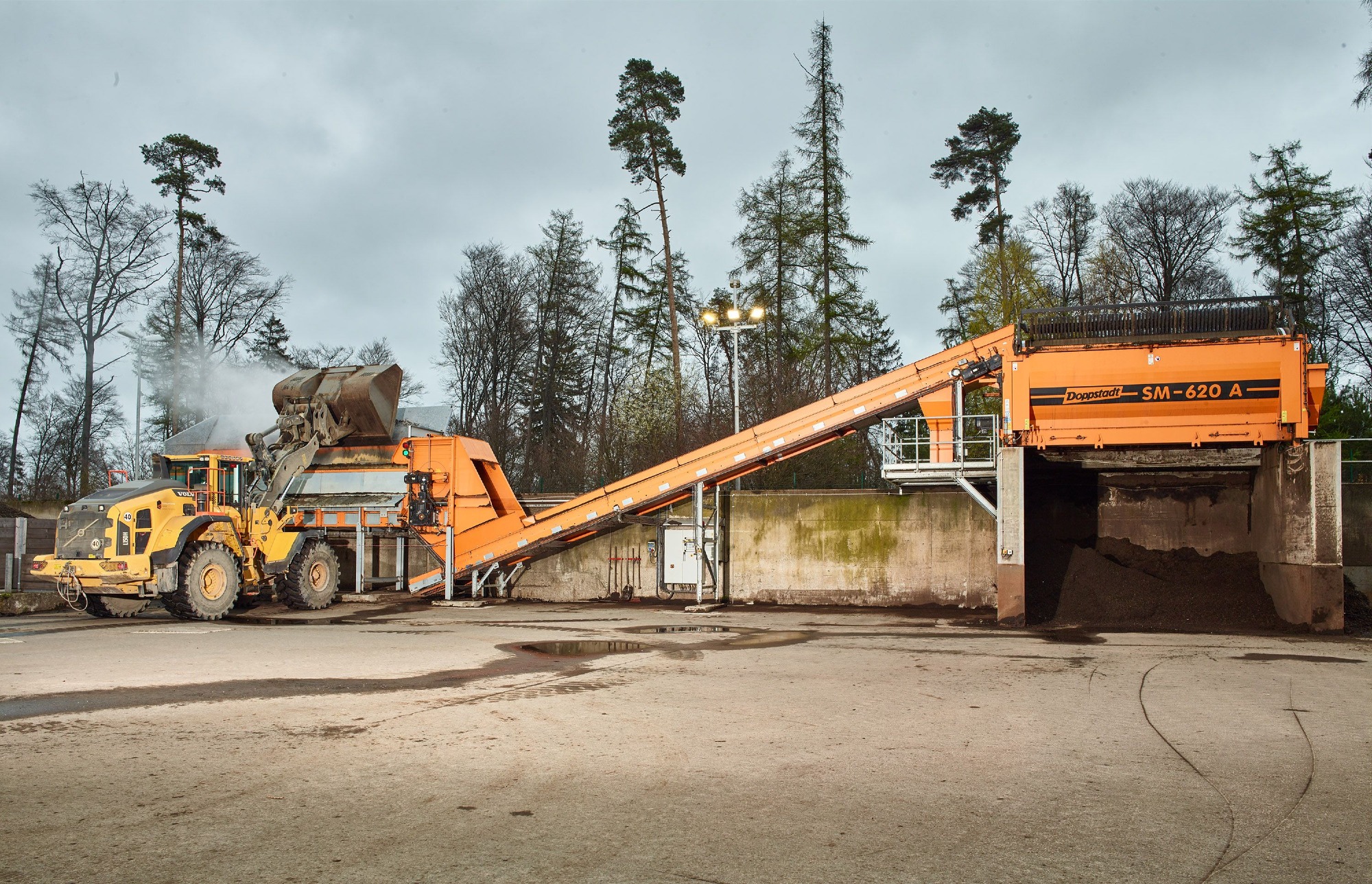 ZAK Kompostierungsanlage mit Förderband und Radlader zur Verarbeitung von Bioabfall zu Qualitätskompost