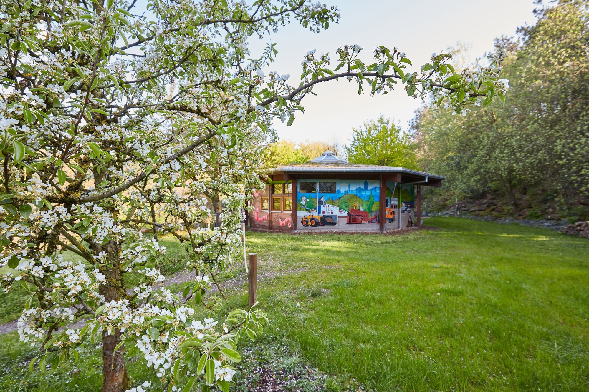 Umwelterlebniszentrum der ZAK zwischen Obstbäumen in Blüte