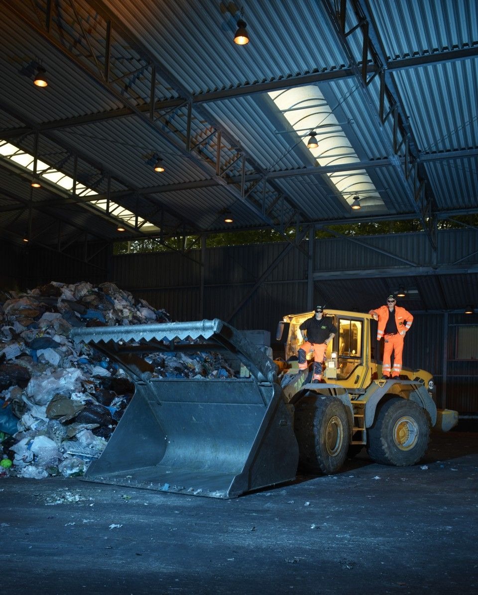 Radlader bewegt Abfallmaterial in der ZAK Umladestation zur Vorbereitung für Transport oder Weiterverarbeitung unter Hallendach