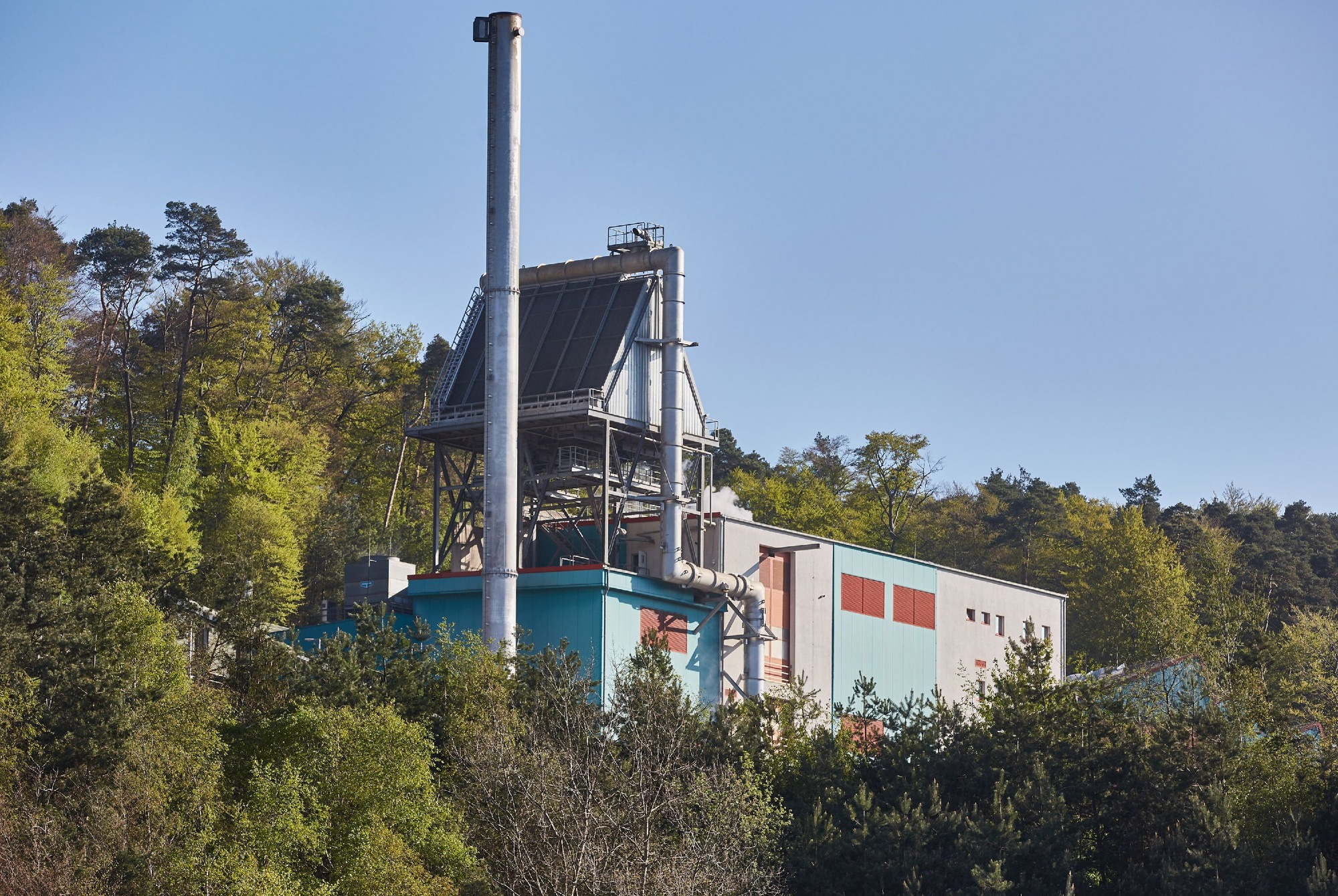 Biomasseheizkraftwerk der ZAK zwischen Waldhügeln zur nachhaltigen Energiegewinnung aus Bioabfällen